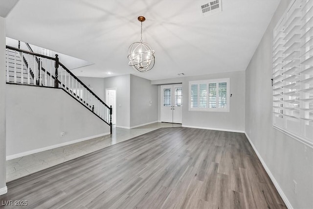 unfurnished living room featuring hardwood / wood-style floors and a chandelier