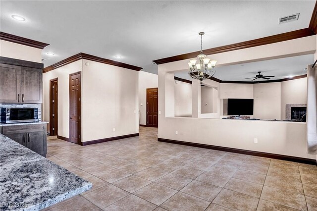 kitchen with stone counters, light tile patterned flooring, and crown molding