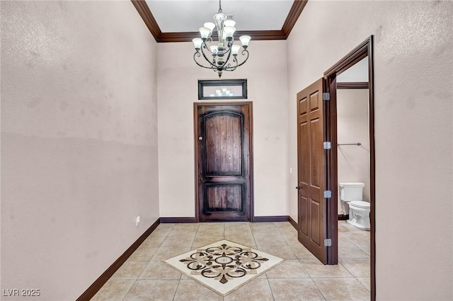 tiled foyer entrance with ornamental molding and an inviting chandelier