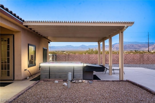 view of patio / terrace featuring a mountain view and a hot tub