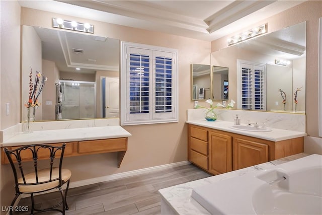 bathroom with a raised ceiling, a stall shower, vanity, wood finished floors, and baseboards