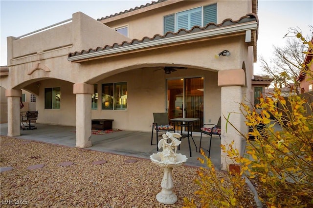 back of house with ceiling fan, a patio, a tiled roof, and stucco siding