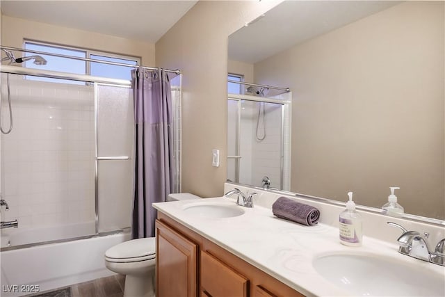 bathroom featuring toilet, shower / tub combo, double vanity, and a sink