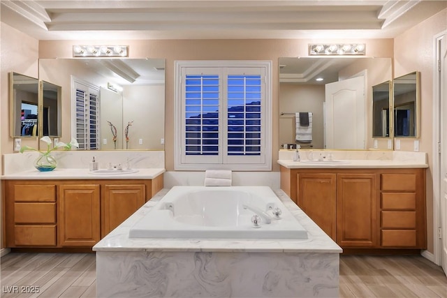 bathroom with two vanities, a sink, and a bath