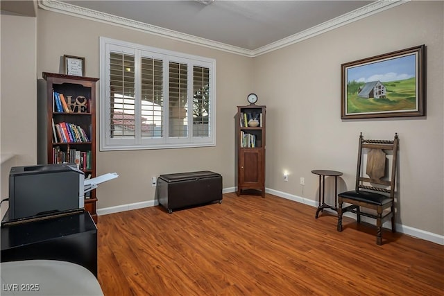 living area featuring ornamental molding, baseboards, and wood finished floors