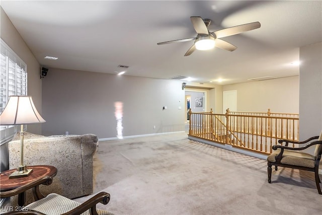 sitting room with carpet, visible vents, baseboards, and an upstairs landing