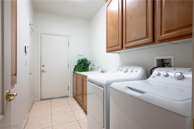 washroom featuring cabinets, light tile patterned flooring, sink, and washer and clothes dryer