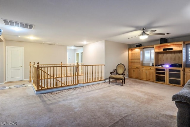 living area featuring light carpet, an upstairs landing, and visible vents