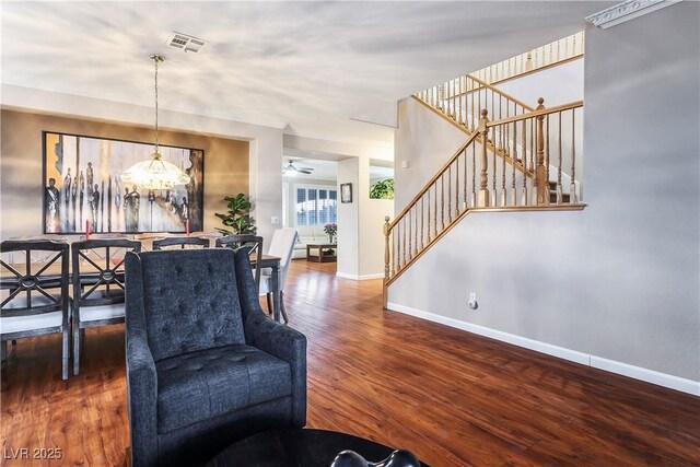 interior space with ceiling fan with notable chandelier and dark wood-type flooring