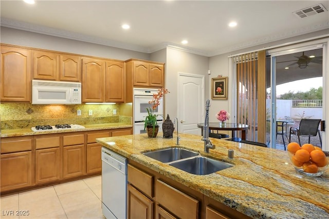 kitchen featuring white appliances, light stone countertops, sink, and decorative backsplash