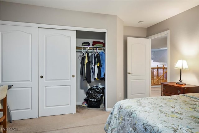 bedroom with a closet, light carpet, and baseboards