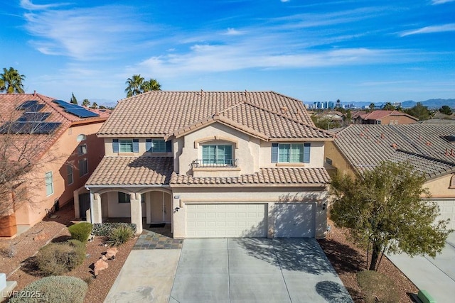 mediterranean / spanish-style house with driveway, a tile roof, and stucco siding