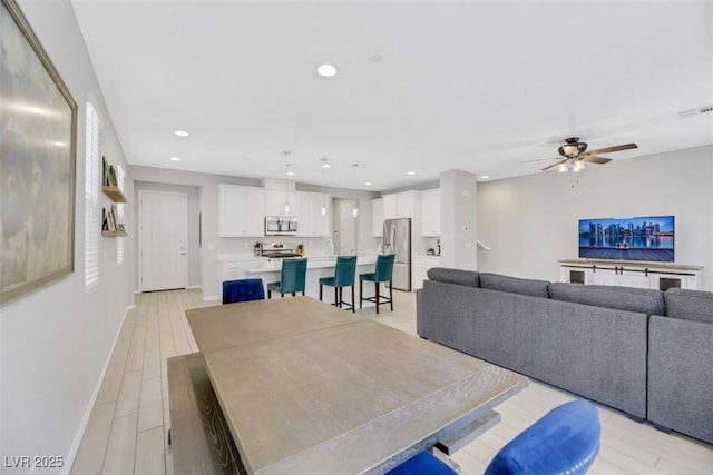 dining room with light hardwood / wood-style flooring and ceiling fan