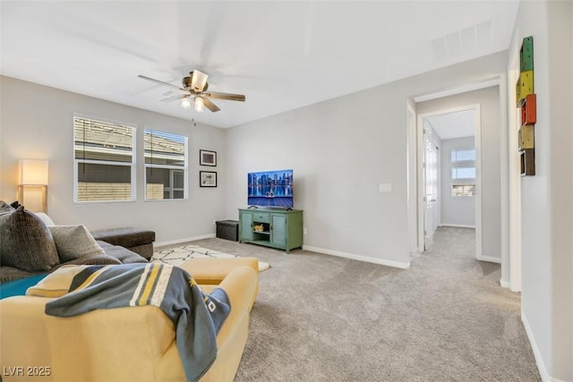 living room featuring a wealth of natural light, light colored carpet, and ceiling fan