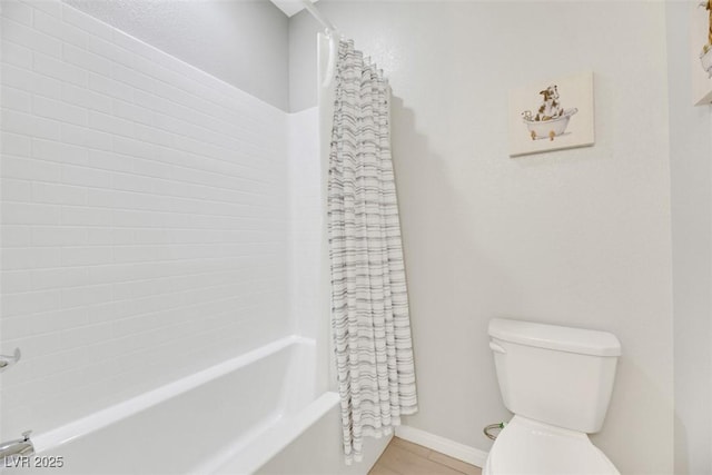 bathroom featuring tile patterned floors, shower / bath combo with shower curtain, and toilet