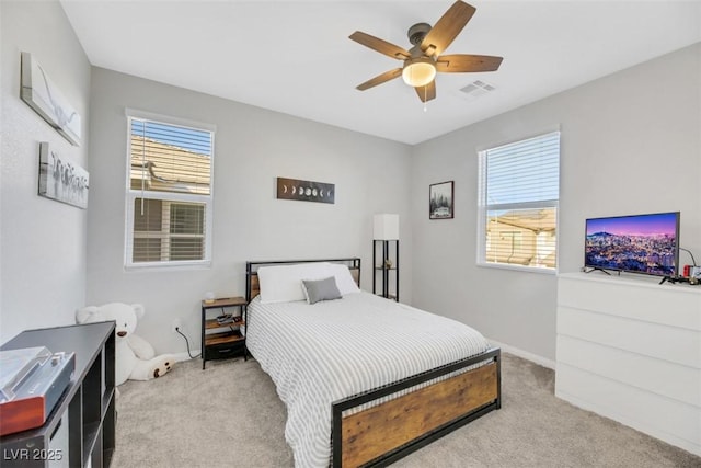 carpeted bedroom with ceiling fan and multiple windows