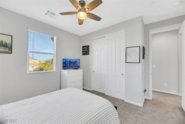 bedroom featuring light carpet, ceiling fan, and a closet