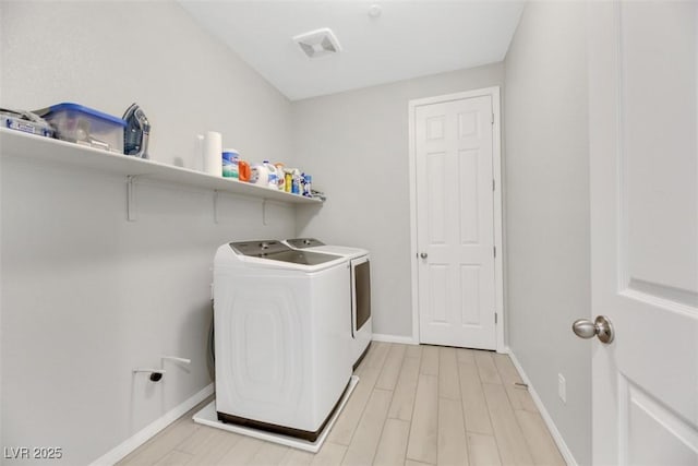 washroom with washer and dryer and light hardwood / wood-style floors