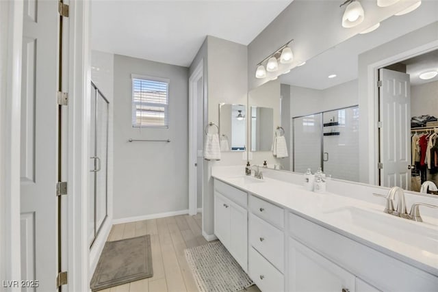 bathroom with vanity, wood-type flooring, and a shower with door