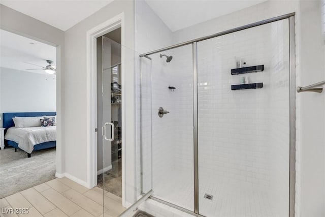 bathroom featuring ceiling fan and a shower with shower door