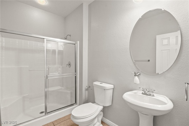 bathroom with walk in shower, sink, tile patterned floors, and toilet