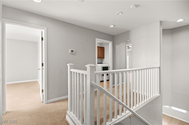 hall featuring washer / clothes dryer and light colored carpet