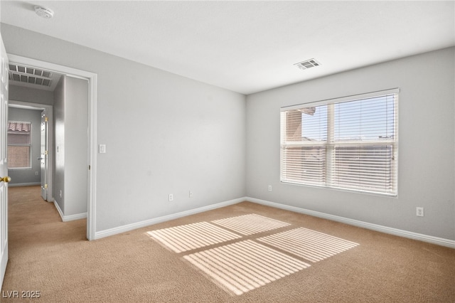 spare room featuring light colored carpet