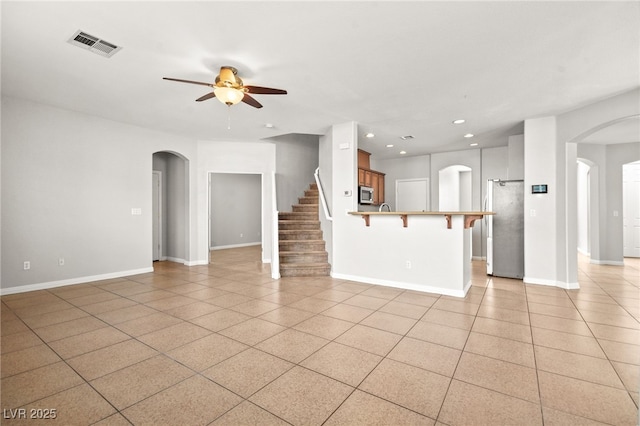 unfurnished living room with light tile patterned floors and ceiling fan