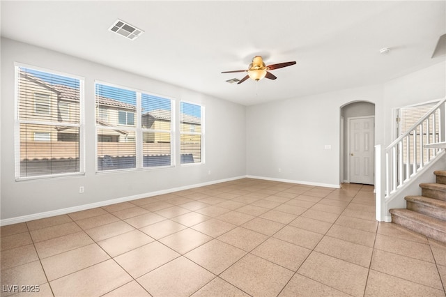 tiled spare room featuring ceiling fan