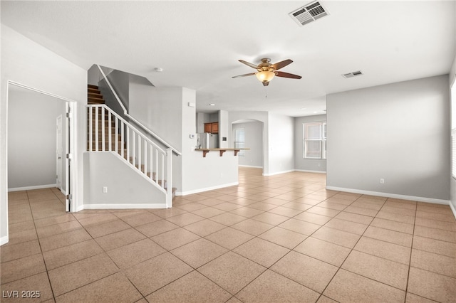 tiled spare room featuring ceiling fan