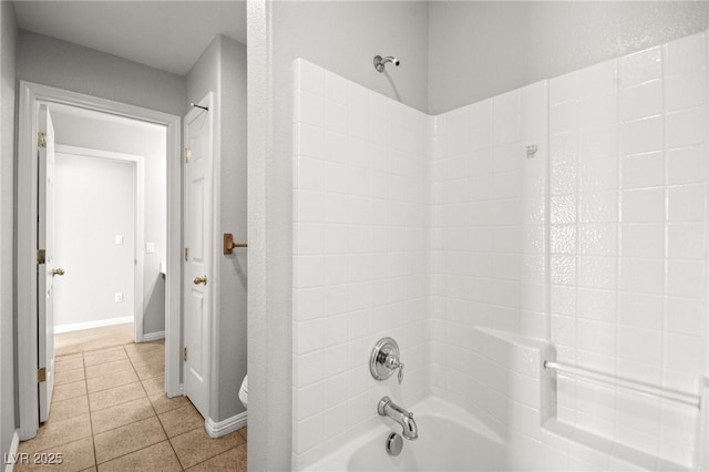 bathroom with tile patterned floors, shower / washtub combination, and toilet