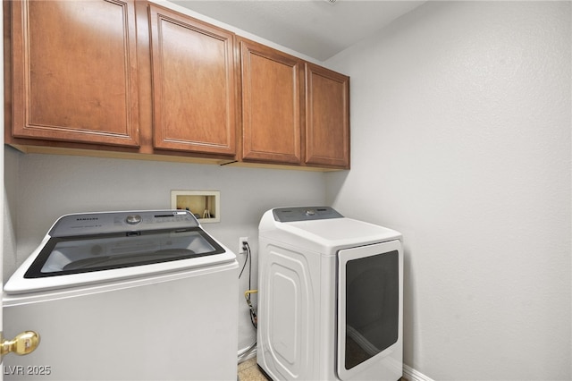 laundry room with independent washer and dryer and cabinets