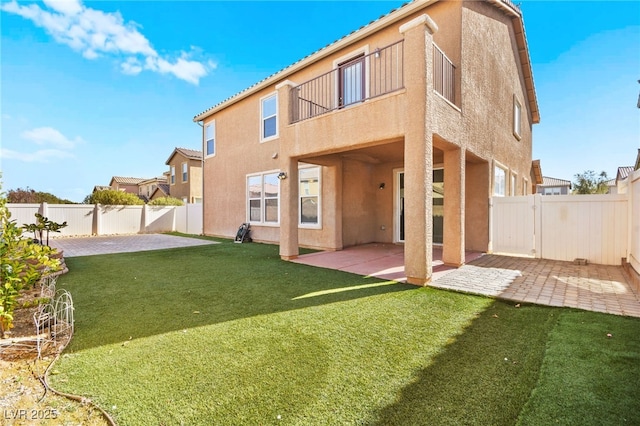 back of house with a patio area and a lawn