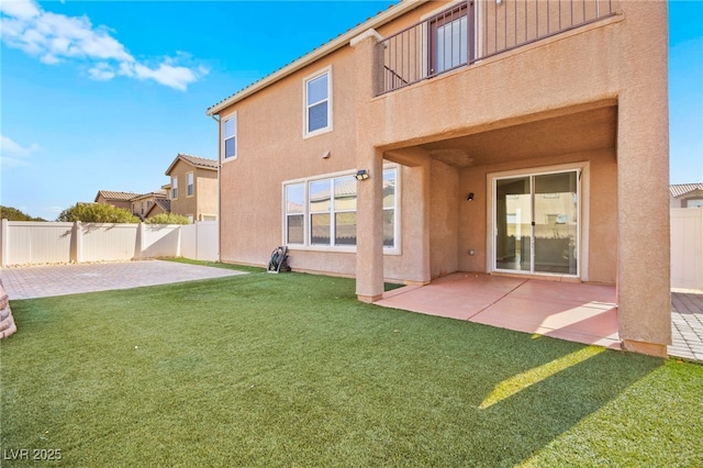 rear view of property featuring a patio area and a lawn