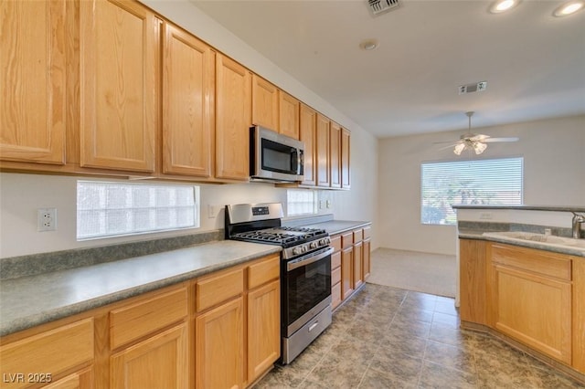 kitchen with ceiling fan, stainless steel appliances, sink, and light brown cabinets