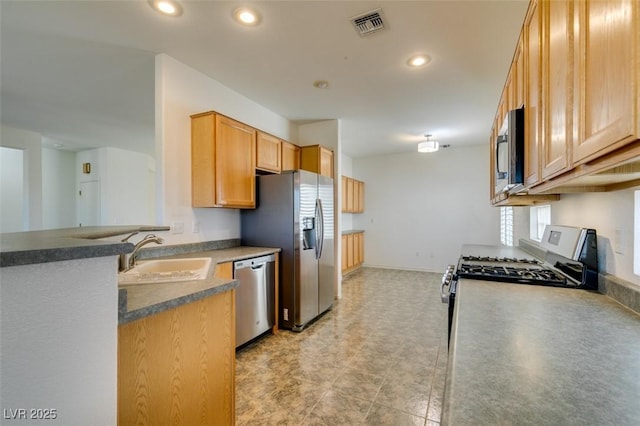 kitchen featuring appliances with stainless steel finishes, sink, and light brown cabinetry