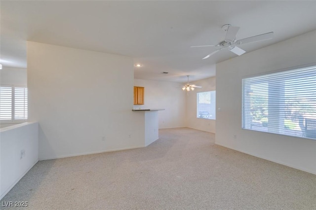 spare room featuring light carpet and ceiling fan