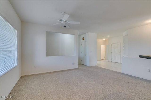 empty room featuring ceiling fan and light carpet