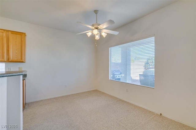 empty room featuring light carpet and ceiling fan