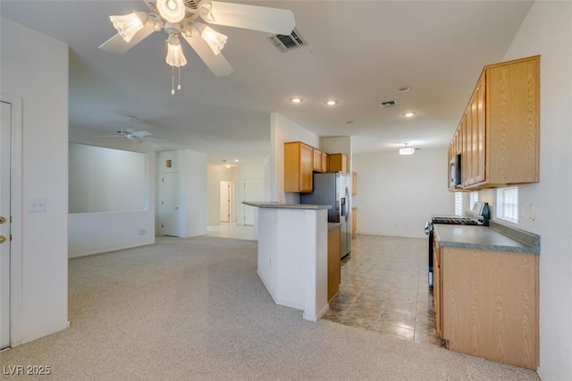 kitchen with ceiling fan, appliances with stainless steel finishes, light carpet, and light brown cabinets