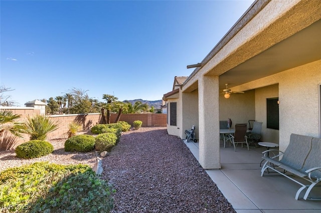 view of yard featuring a patio, a mountain view, and ceiling fan