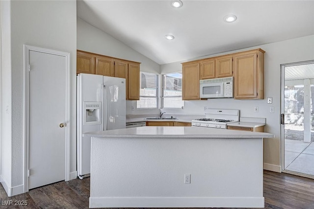 kitchen with white appliances, lofted ceiling, a center island, and sink