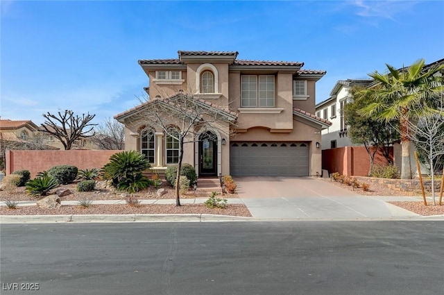 mediterranean / spanish home featuring fence, driveway, an attached garage, and stucco siding