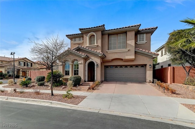 mediterranean / spanish-style home featuring a garage, driveway, a tiled roof, fence, and stucco siding