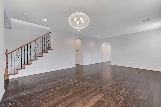 unfurnished living room with dark hardwood / wood-style flooring and a chandelier