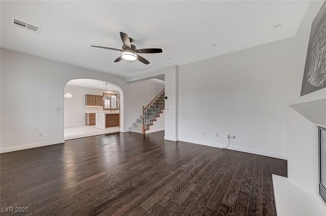 unfurnished living room featuring ceiling fan and dark hardwood / wood-style flooring