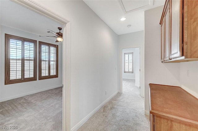 hall with recessed lighting, light colored carpet, and baseboards