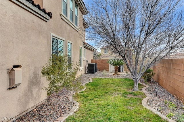 view of yard with a fenced backyard and central AC