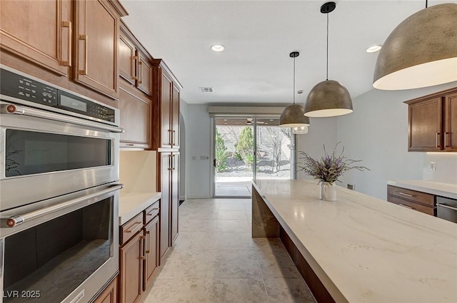 kitchen featuring double oven, recessed lighting, visible vents, hanging light fixtures, and light stone countertops