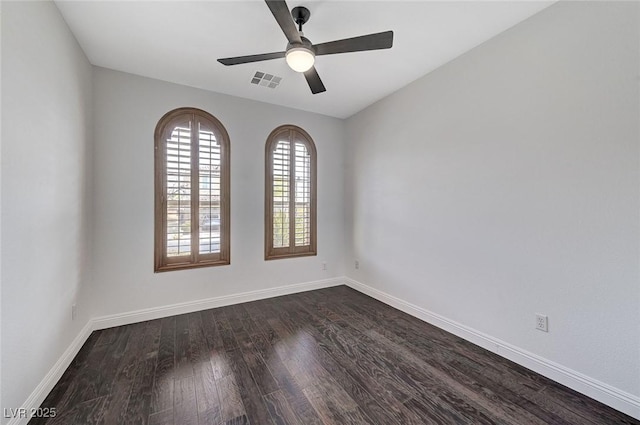 unfurnished room with ceiling fan, dark wood-style flooring, visible vents, and baseboards